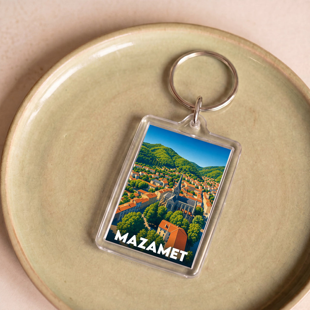 Porte-clés souvenir de la ville de Mazamet avec une illustration stylisée.