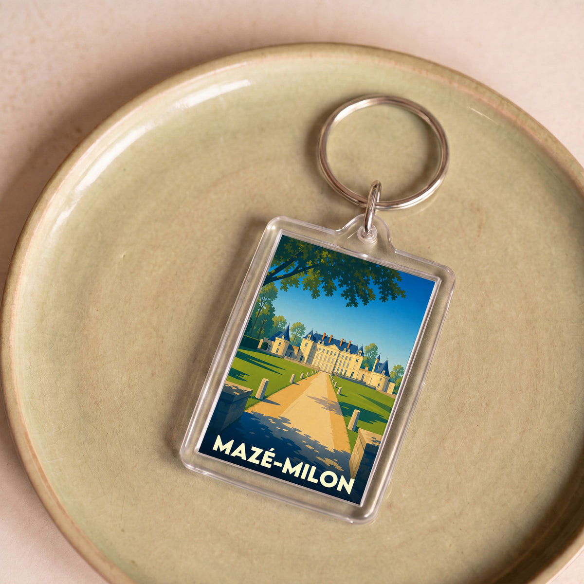 Porte-clés souvenir de la ville de Mazé-Milon avec une illustration stylisée de son château.