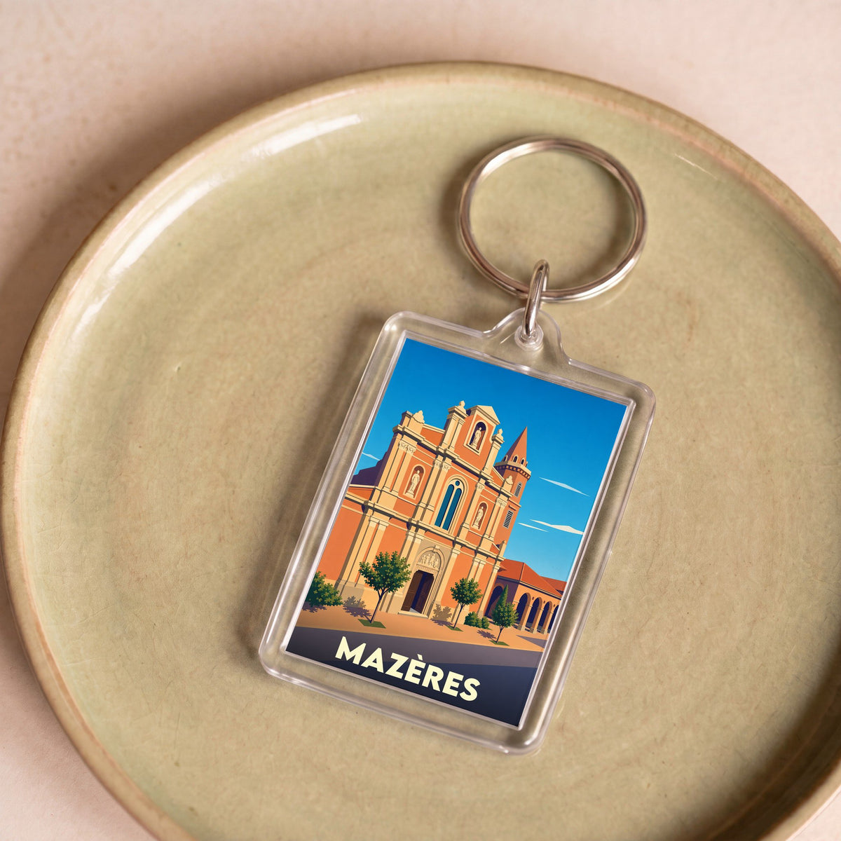 Porte-clés souvenir de la ville de Mazères avec une illustration stylisée de son église.
