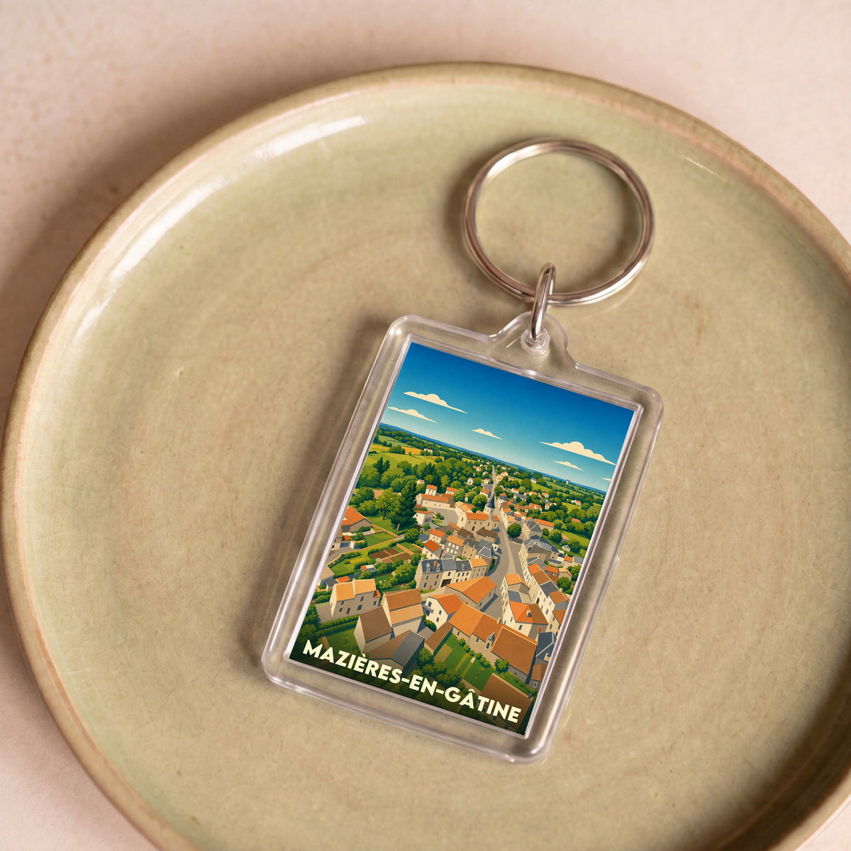 Porte-clés souvenir de la ville de Mazières-en-Gâtine avec une illustration stylisée d'une vue aérienne.