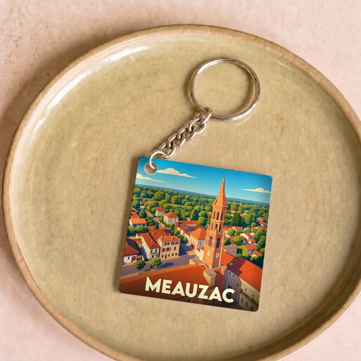 Porte-clés souvenir de la ville de Meauzac avec une illustration stylisée.