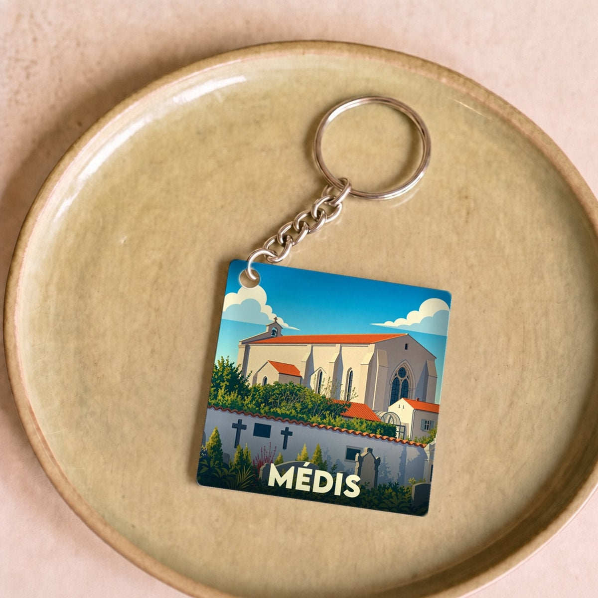 Porte-clés souvenir de la ville de Médis avec une illustration stylisée de son église.