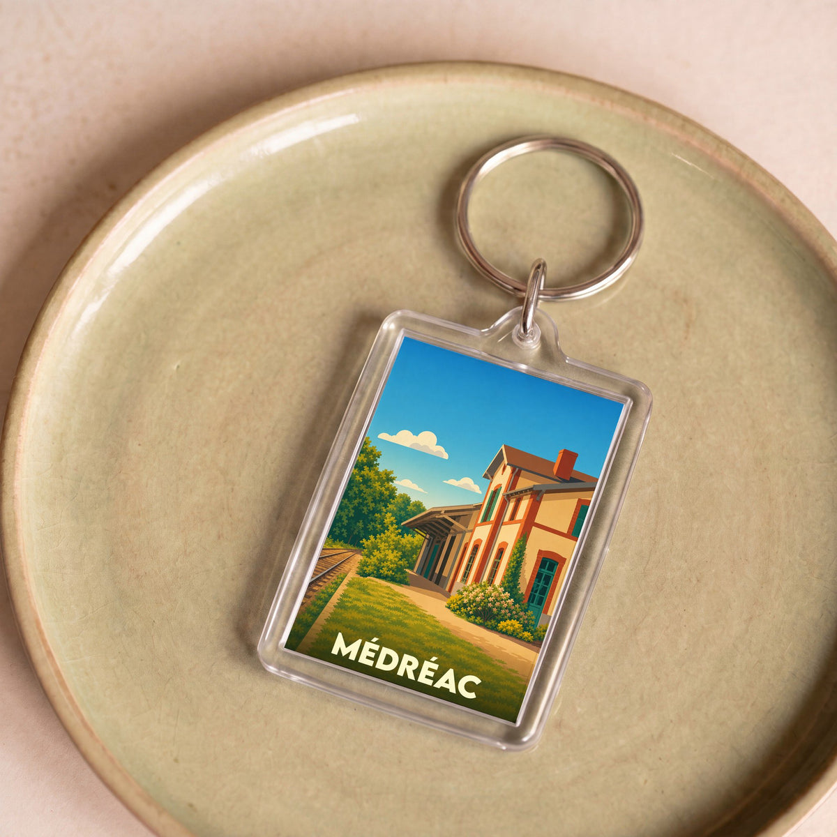 Porte-clés souvenir de la ville de Médréac avec une illustration stylisée de son ancienne gare.