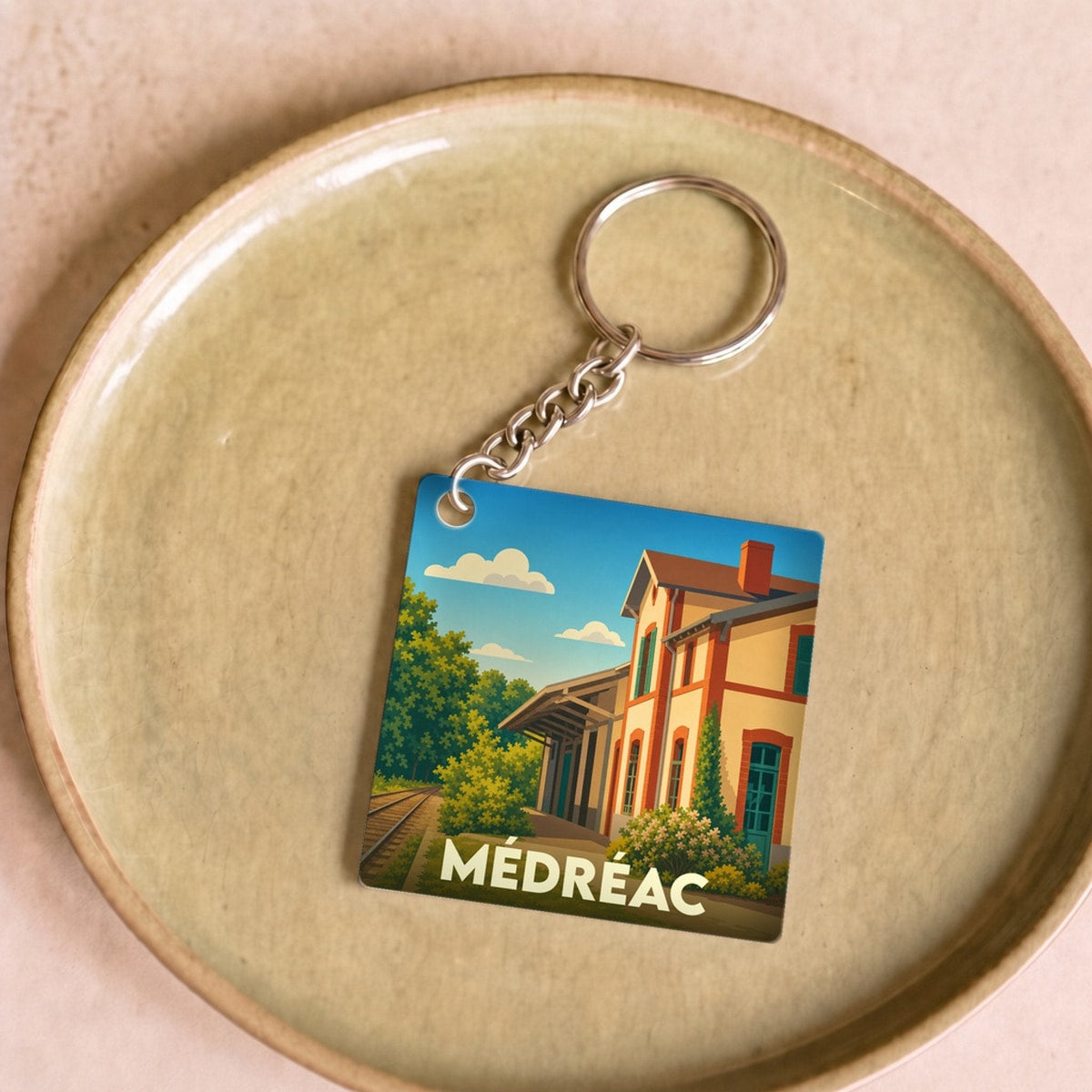 Porte-clés souvenir de la ville de Médréac avec une illustration stylisée de son ancienne gare.