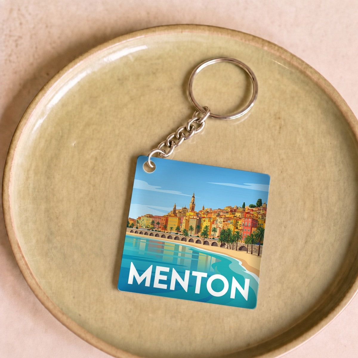 Porte-clés souvenir de la ville de Menton avec une illustration stylisée et colorée.