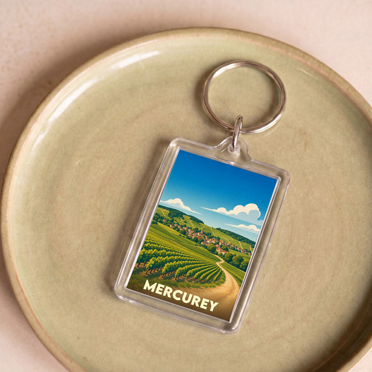 Porte-clés souvenir de la ville de Mercurey avec une illustration stylisée de vignobles.