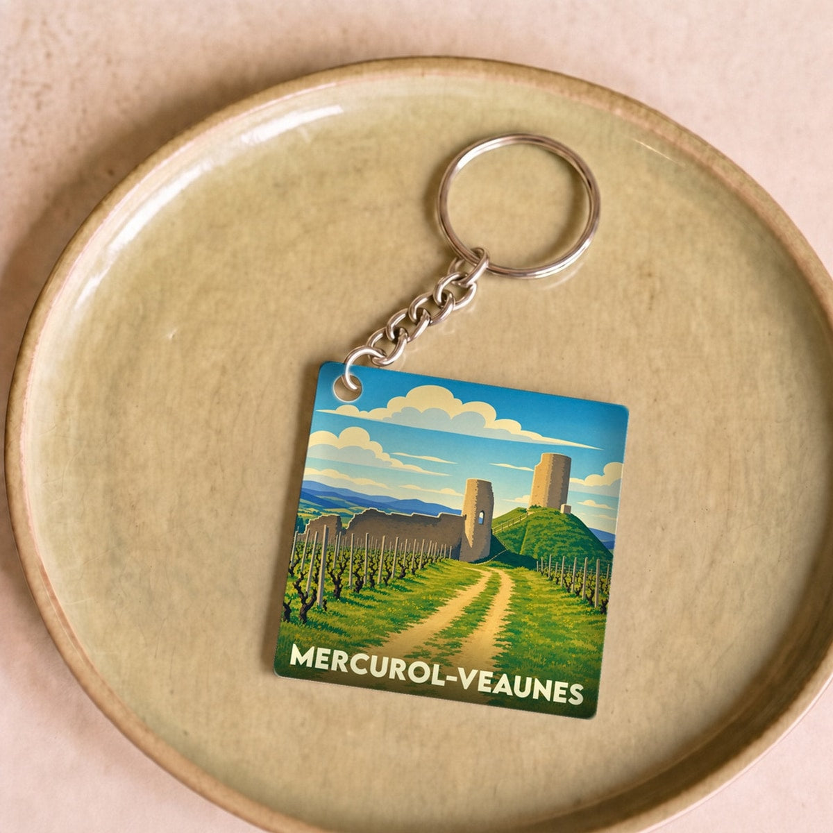 Porte-clés souvenir de la ville de Mercurol-Veaunes avec une illustration stylisée de ses paysages et châteaux.