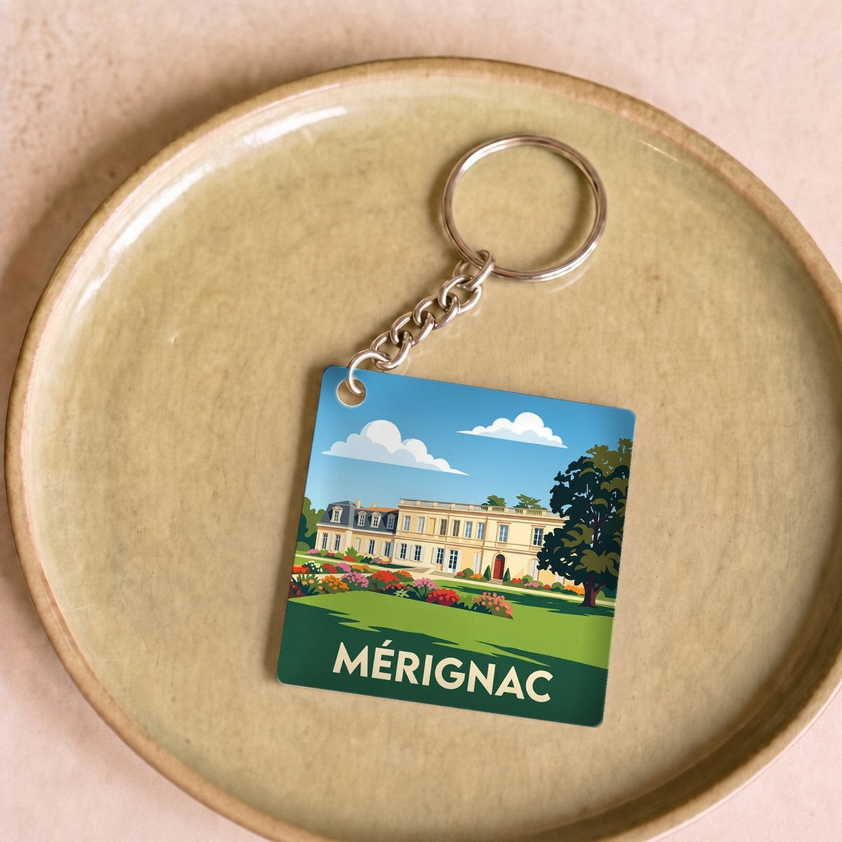 Porte-clés souvenir de la ville de Mérignac avec une illustration stylisée.