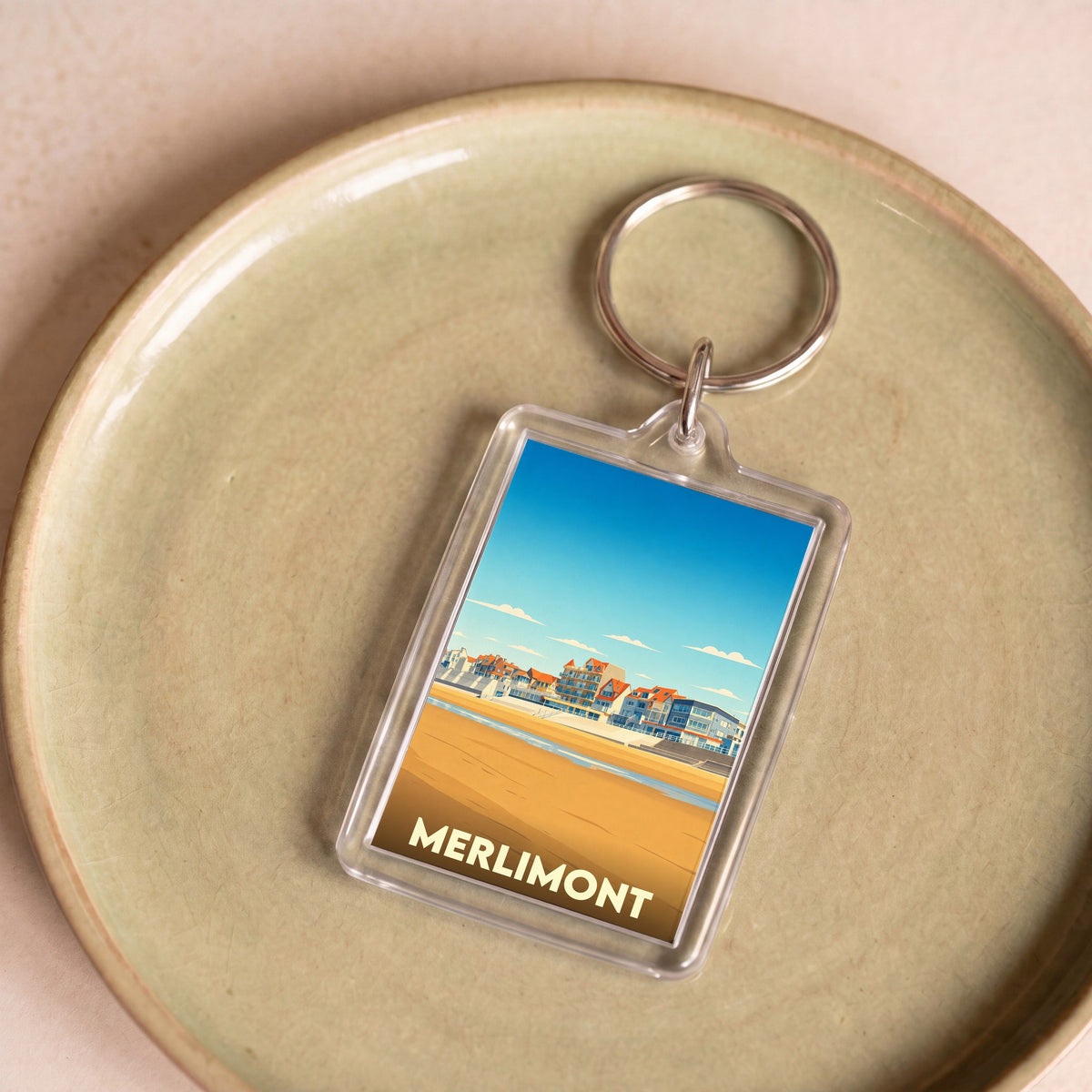 Porte-clés souvenir de la ville de Merlimont avec une illustration stylisée de son front de mer.