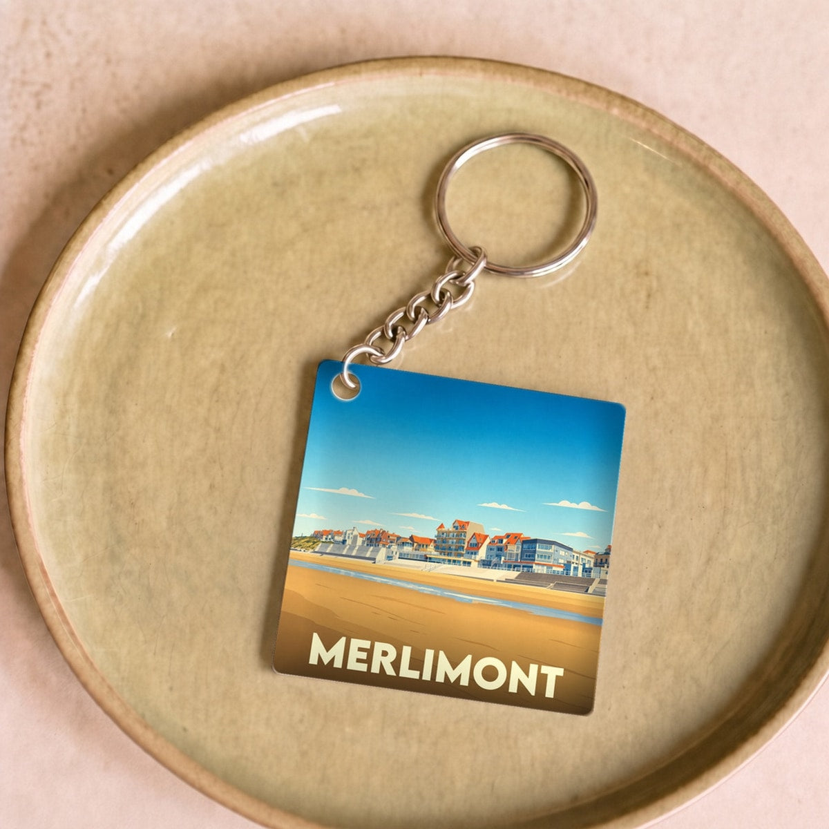 Porte-clés souvenir de la ville de Merlimont avec une illustration stylisée de son front de mer.