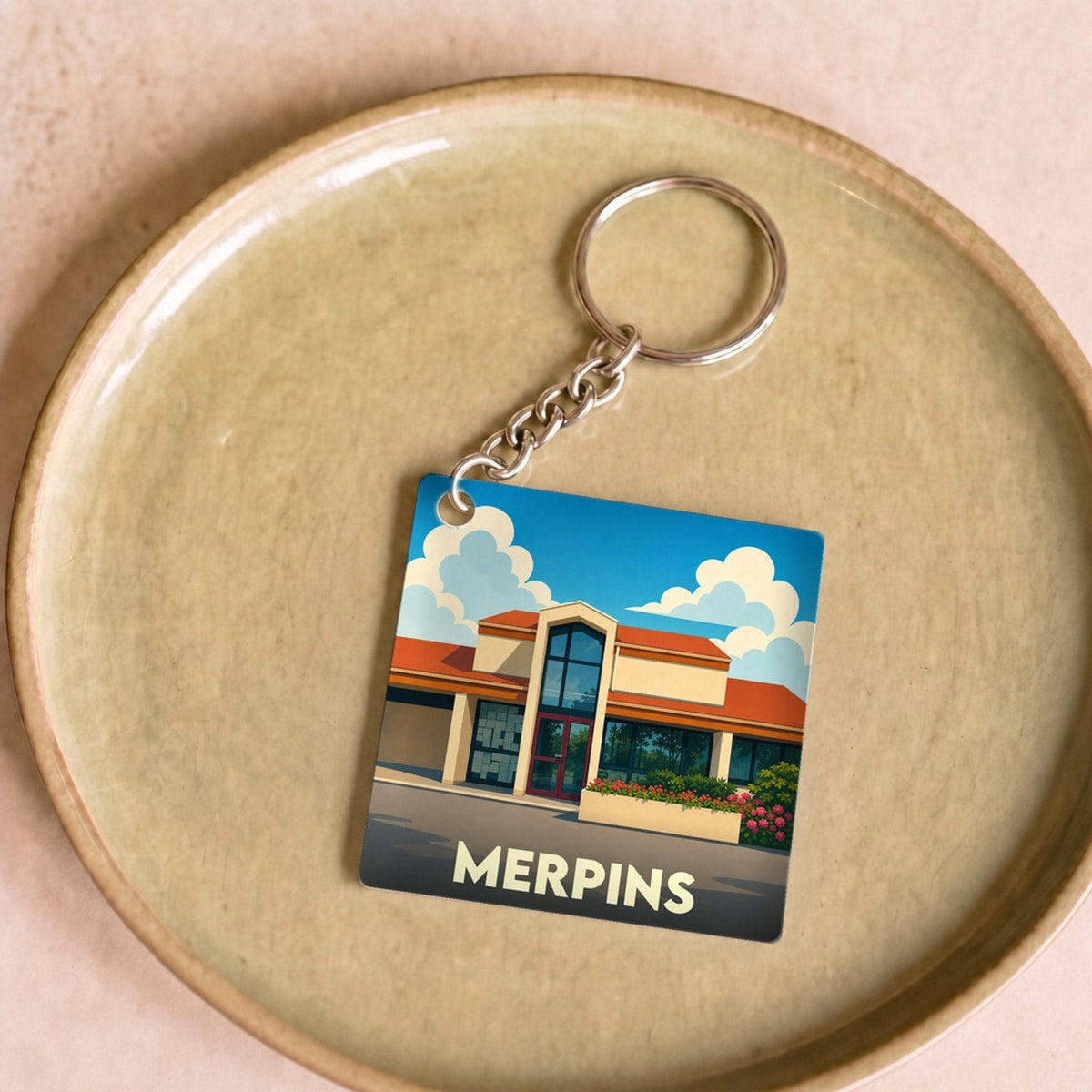 Porte-clés souvenir de la ville de Merpins avec une illustration stylisée.