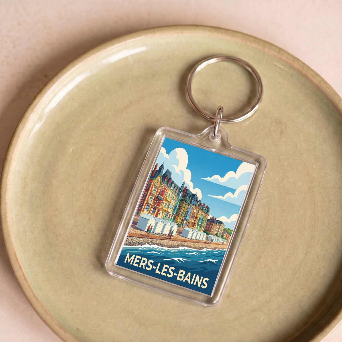 Porte-clés souvenir de la ville de Mers-les-Bains avec une illustration stylisée de son front de mer coloré.