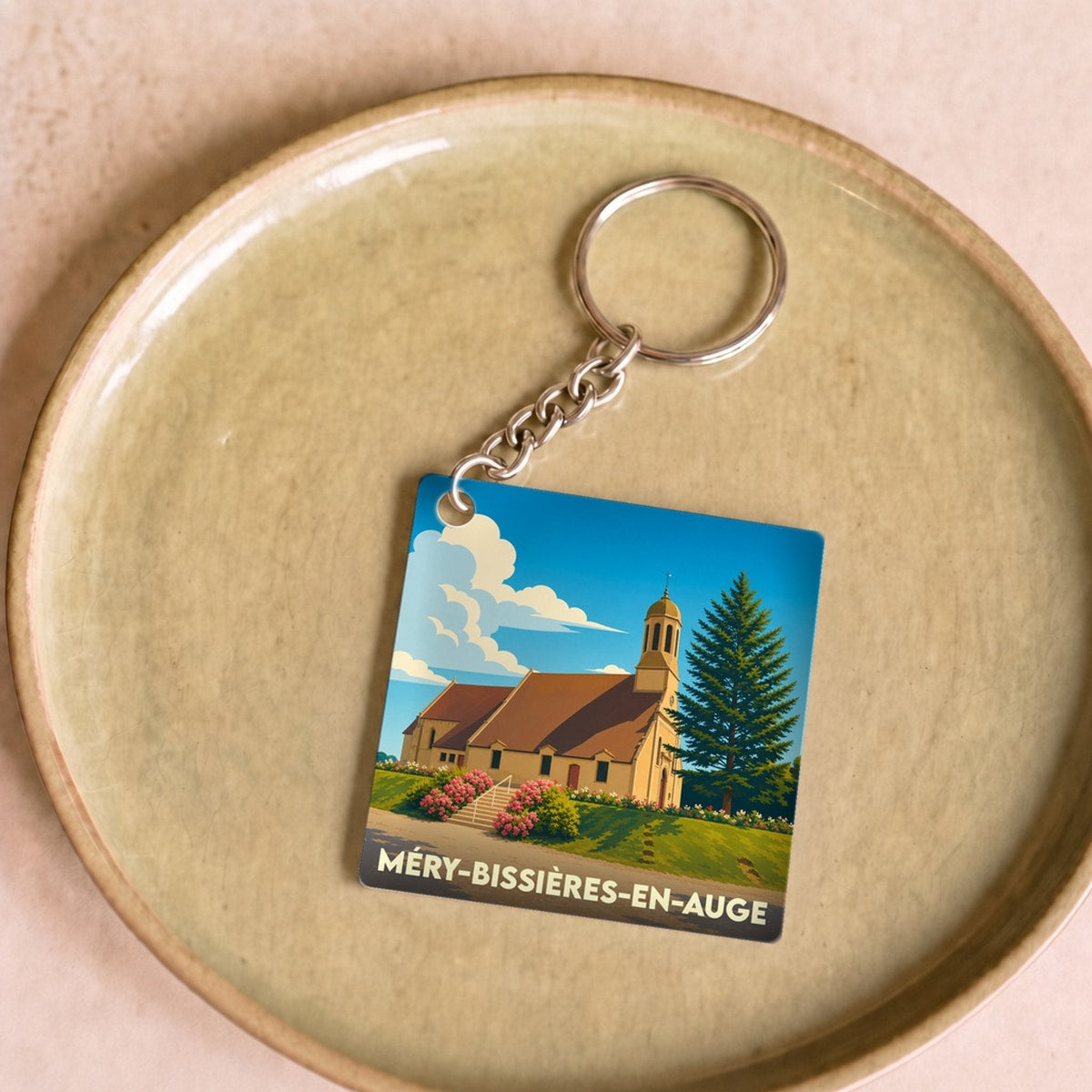 Porte-clés souvenir de Méry-Bissières-en-Auge avec une illustration stylisée de l'église locale.