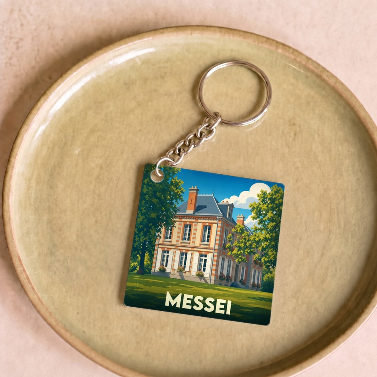 Porte-clés souvenir de la ville de Messei avec une illustration stylisée de son château.