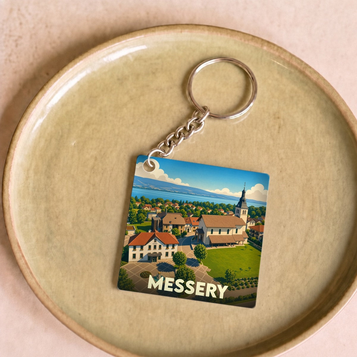 Porte-clés souvenir de la ville de Messery avec une illustration stylisée.