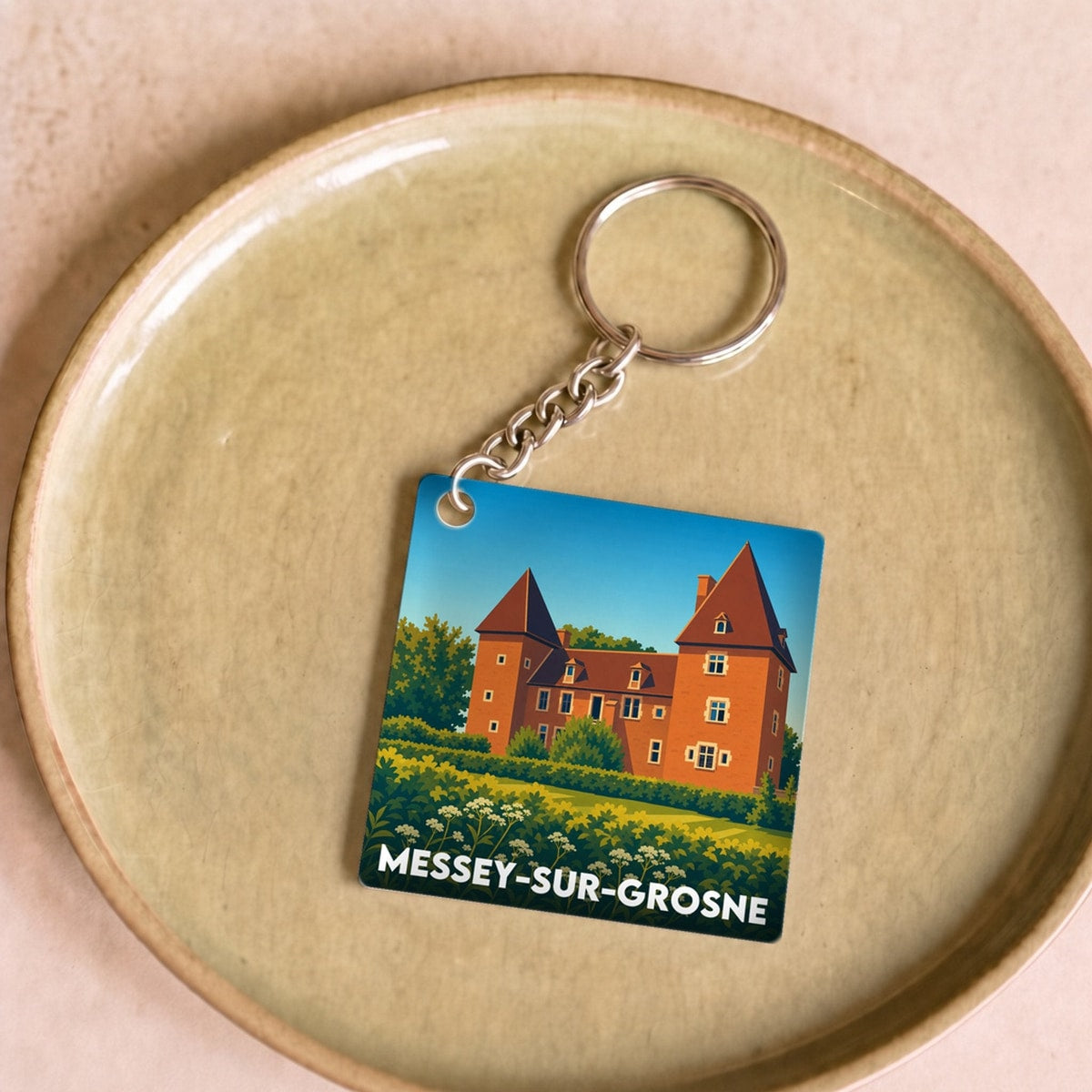 Porte-clés souvenir de la ville de Messey-sur-Grosne avec une illustration stylisée.