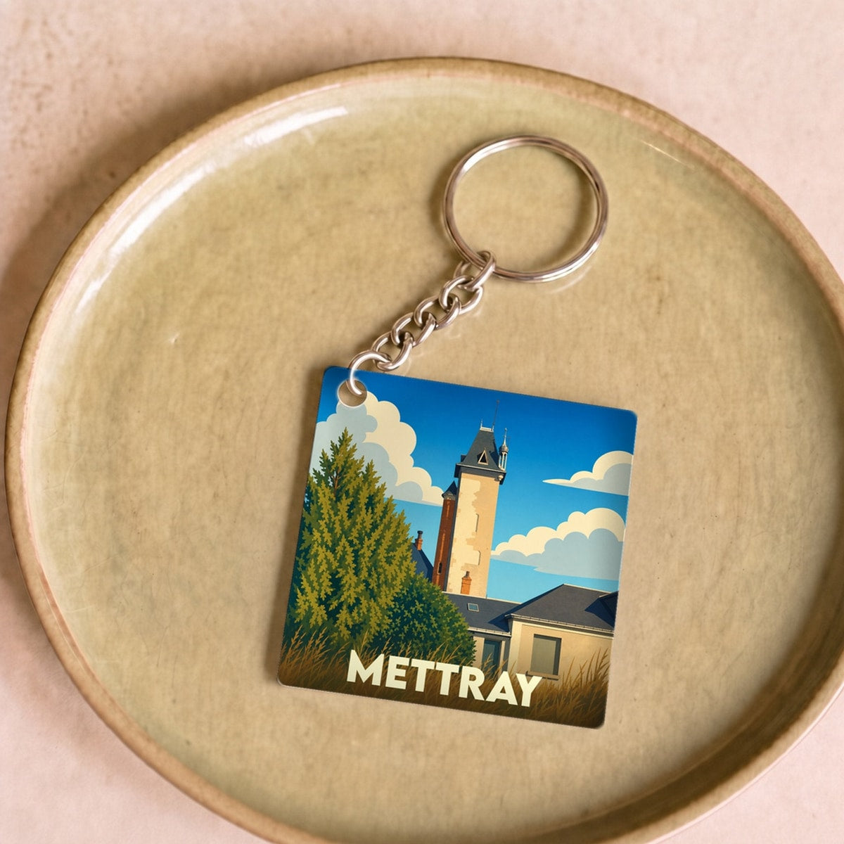 Porte-clés souvenir de la ville de Mettray avec une illustration stylisée.