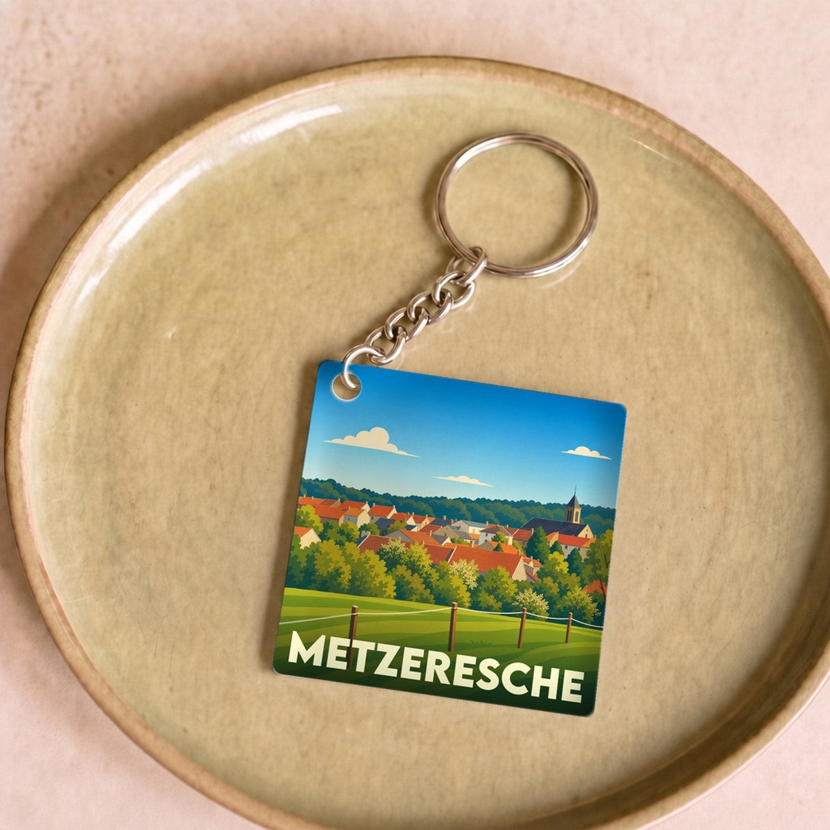 Porte-clés souvenir de la ville de Metzeresche avec une illustration stylisée.
