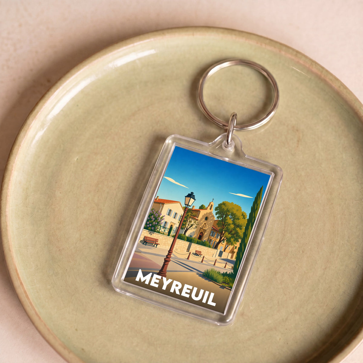 Porte-clés souvenir de la ville de Meyreuil avec une illustration stylisée.