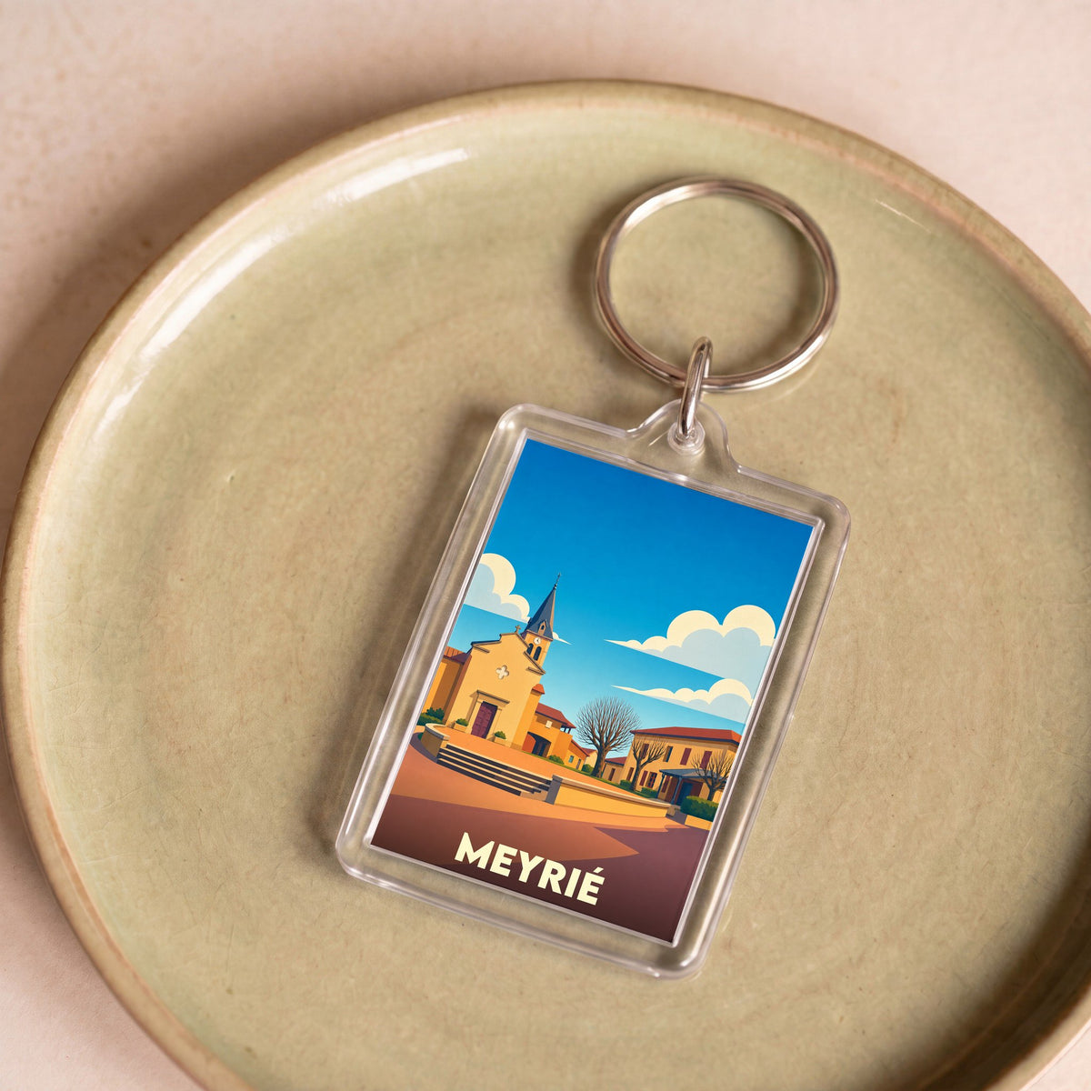 Porte-clés souvenir de la ville de Meyrié avec une illustration stylisée de son église.