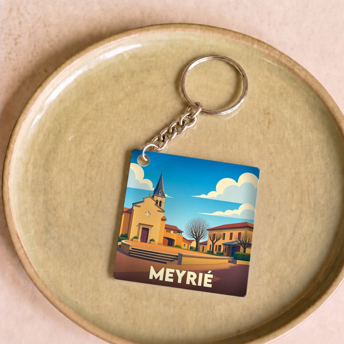 Porte-clés souvenir de la ville de Meyrié avec une illustration stylisée de son église.