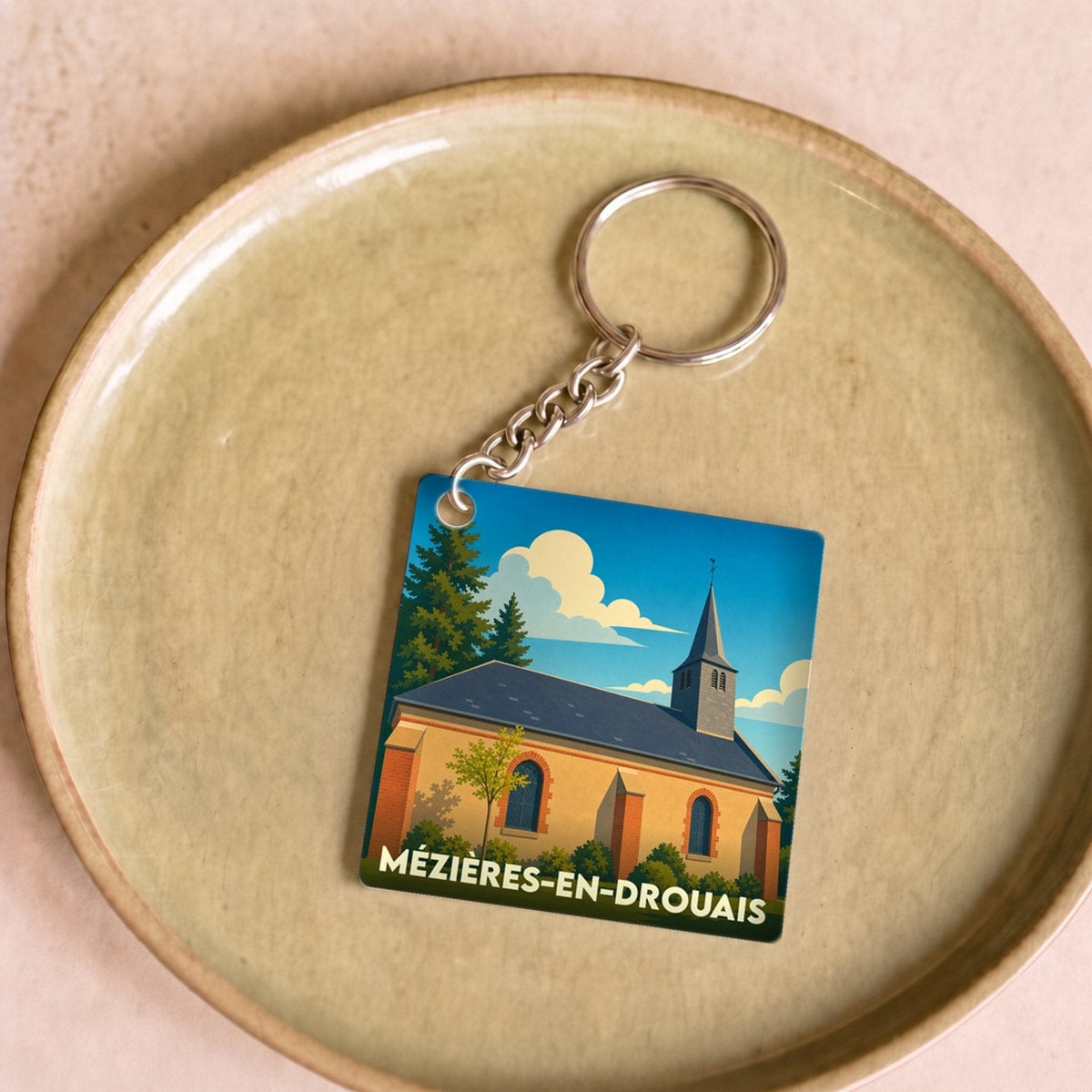 Porte-clés souvenir de la ville de Mézières-en-Drouais avec une illustration stylisée de son église.