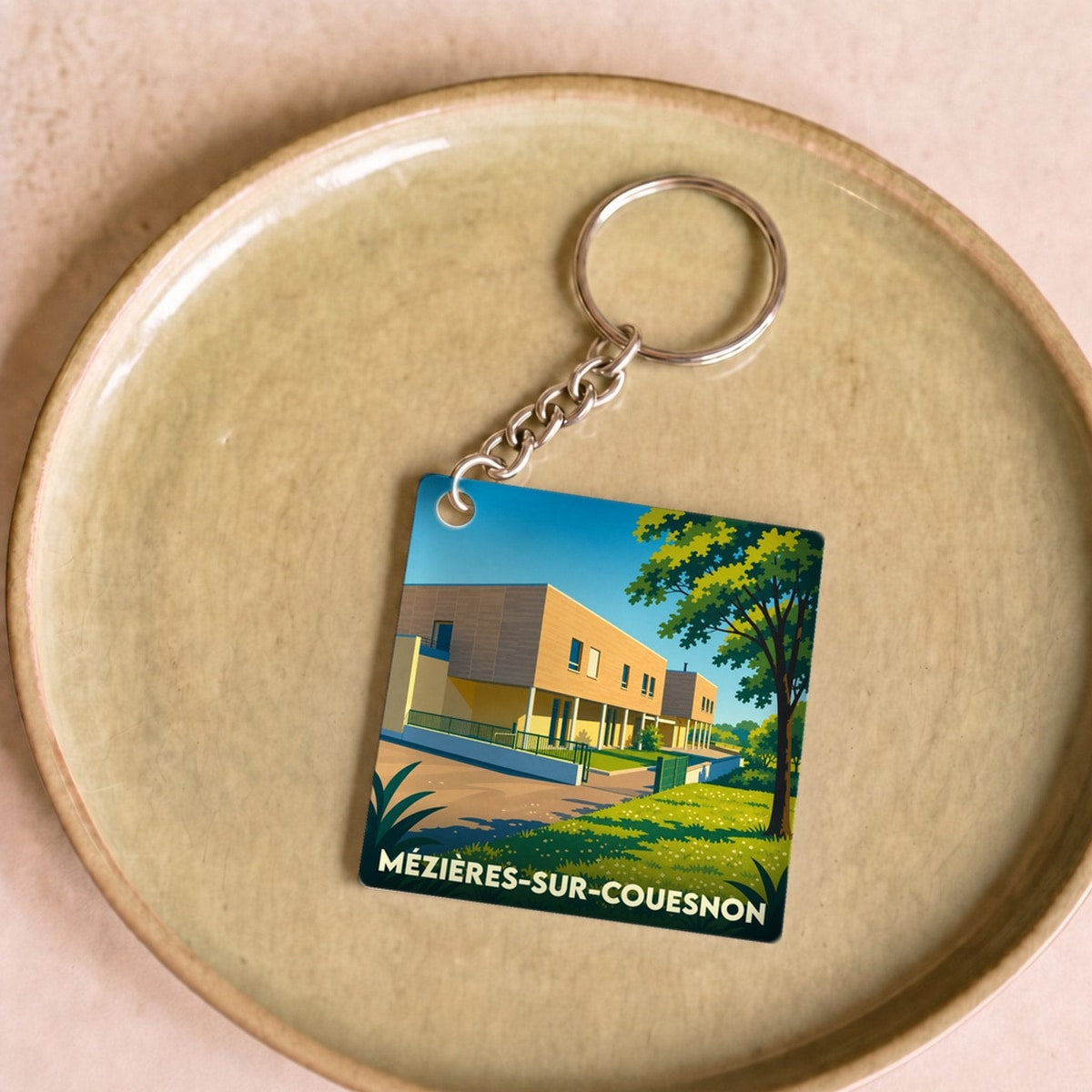 Porte-clés souvenir de la ville de Mézières-sur-Couesnon avec une illustration stylisée.