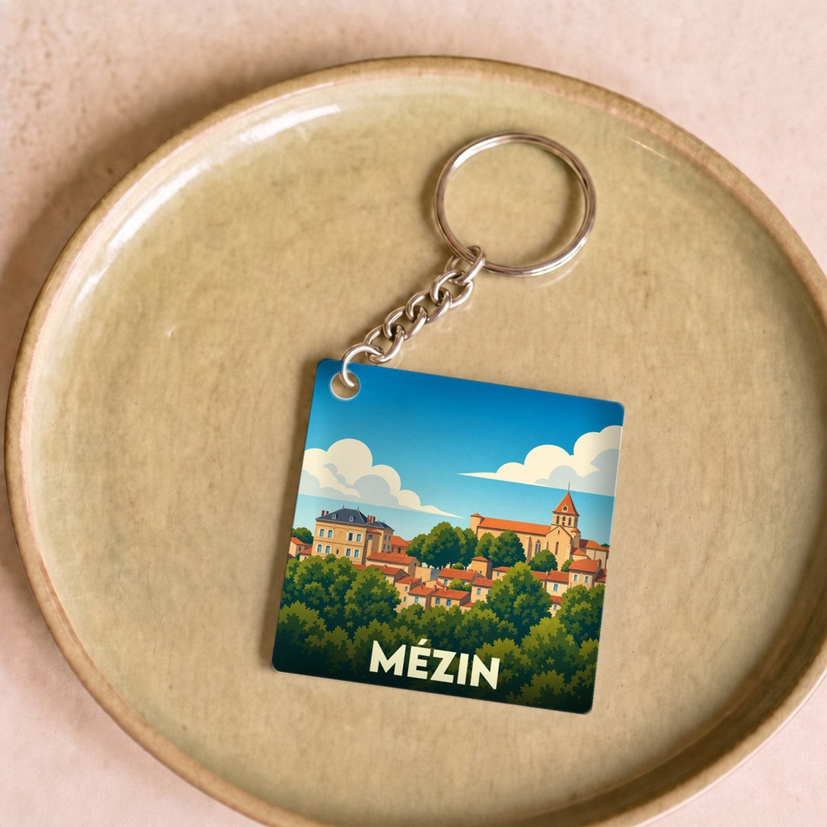 Porte-clés souvenir de la ville de Mézin avec une illustration stylisée.