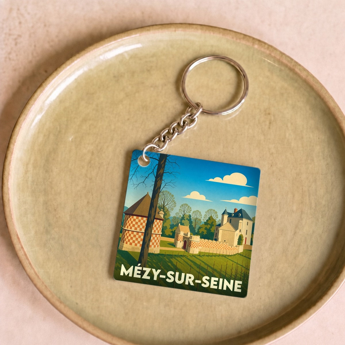 Porte-clés souvenir de la ville de Mézy-sur-Seine avec une illustration stylisée d'un domaine historique.