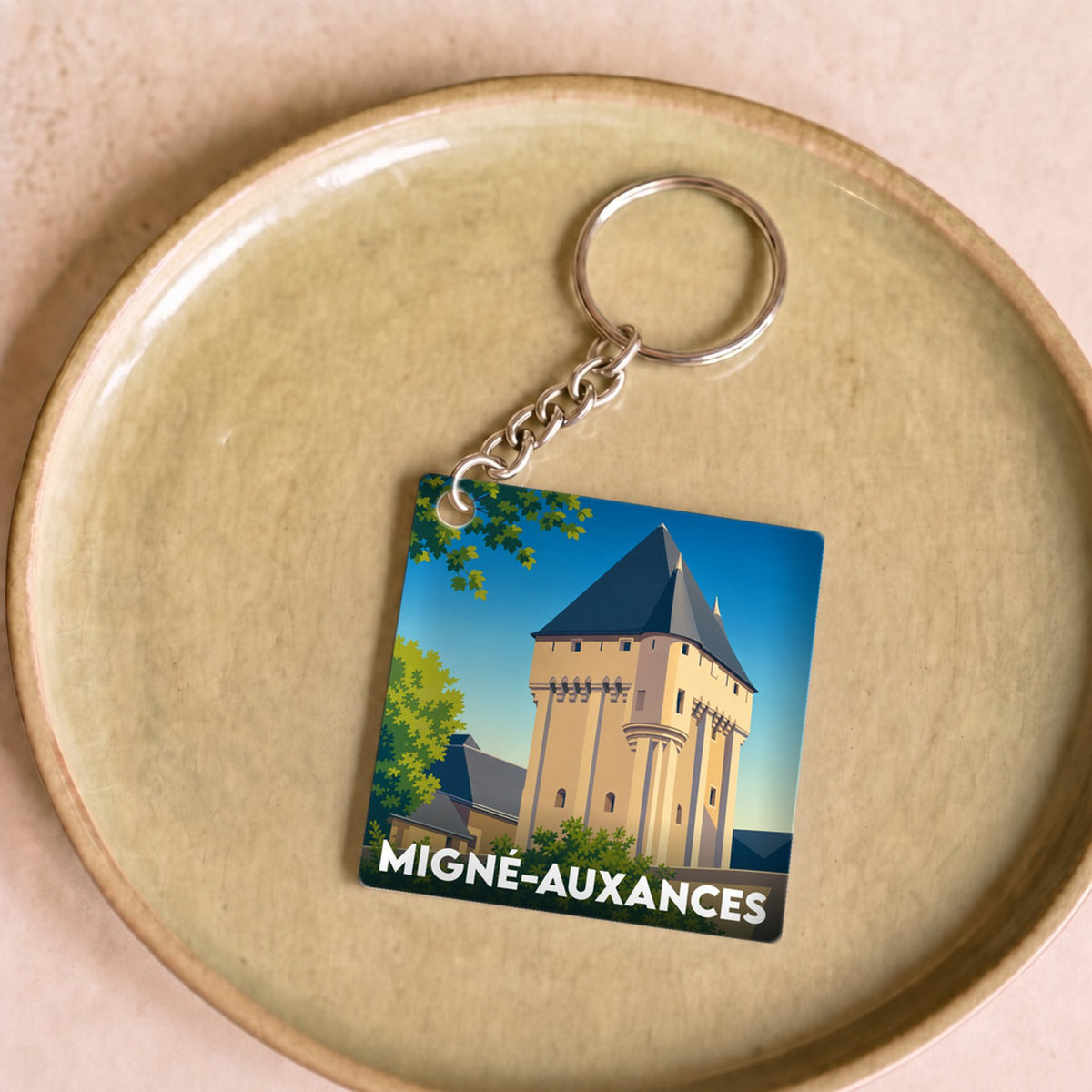 Porte-clés souvenir de la ville de Migné-Auxances avec une illustration stylisée de son patrimoine.