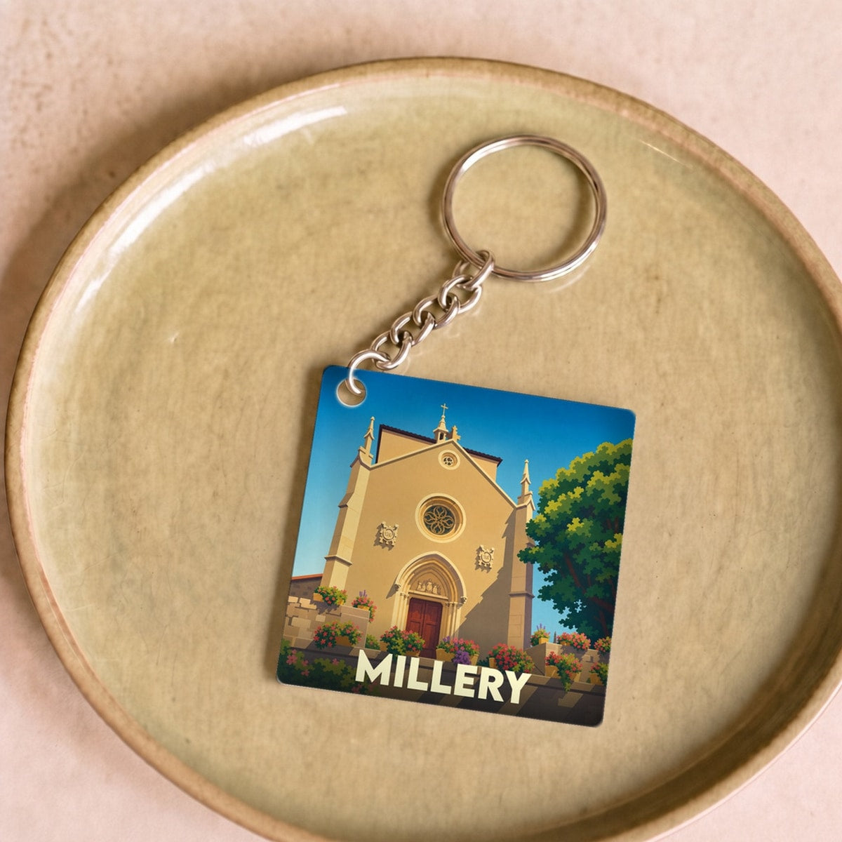 Porte-clés souvenir de la ville de Millery avec une illustration stylisée de son église.