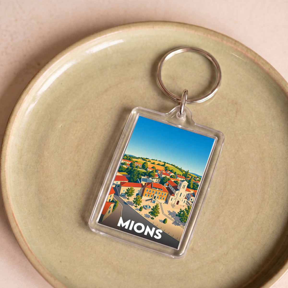 Porte-clés souvenir de la ville de Mions avec une illustration stylisée.