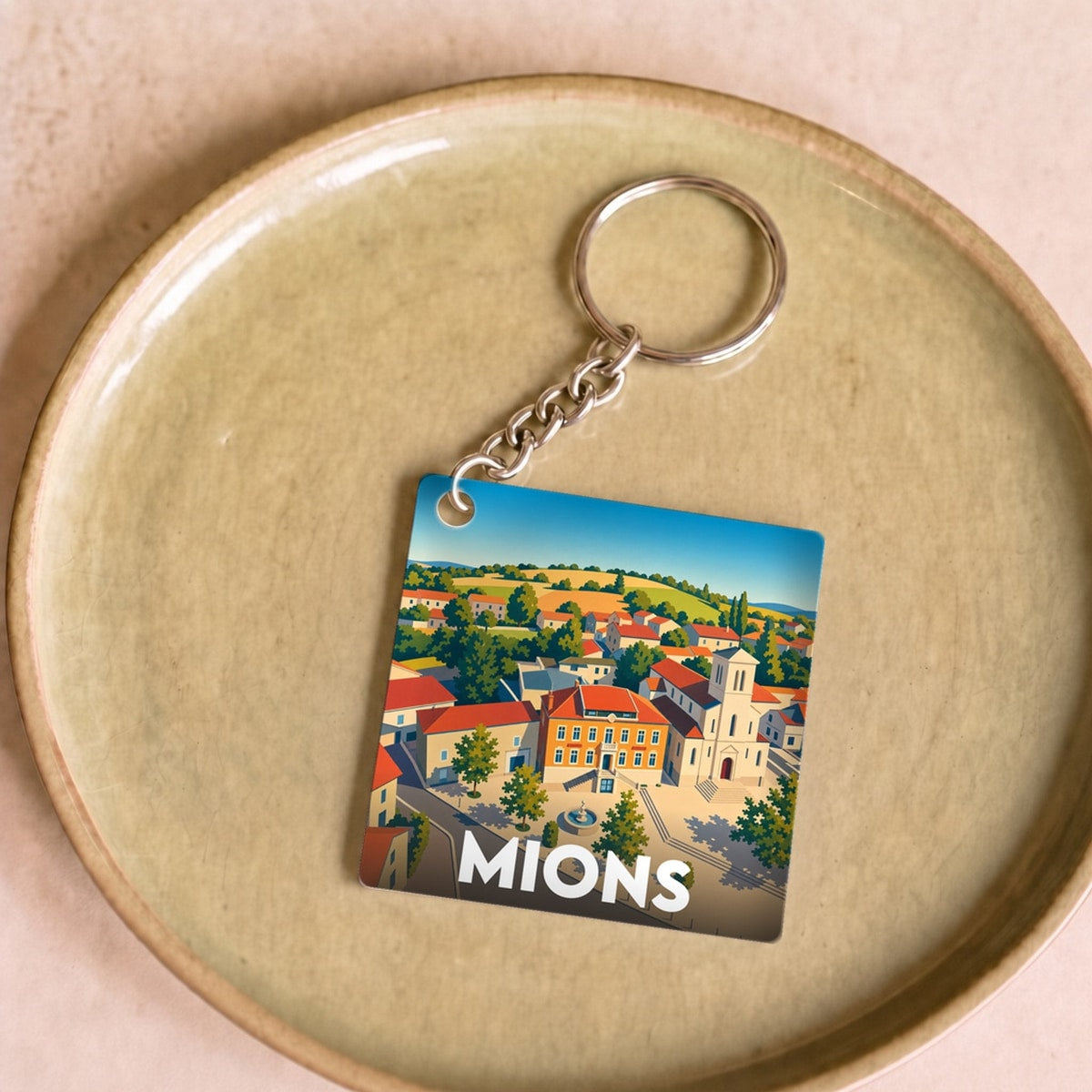 Porte-clés souvenir de la ville de Mions avec une illustration stylisée.