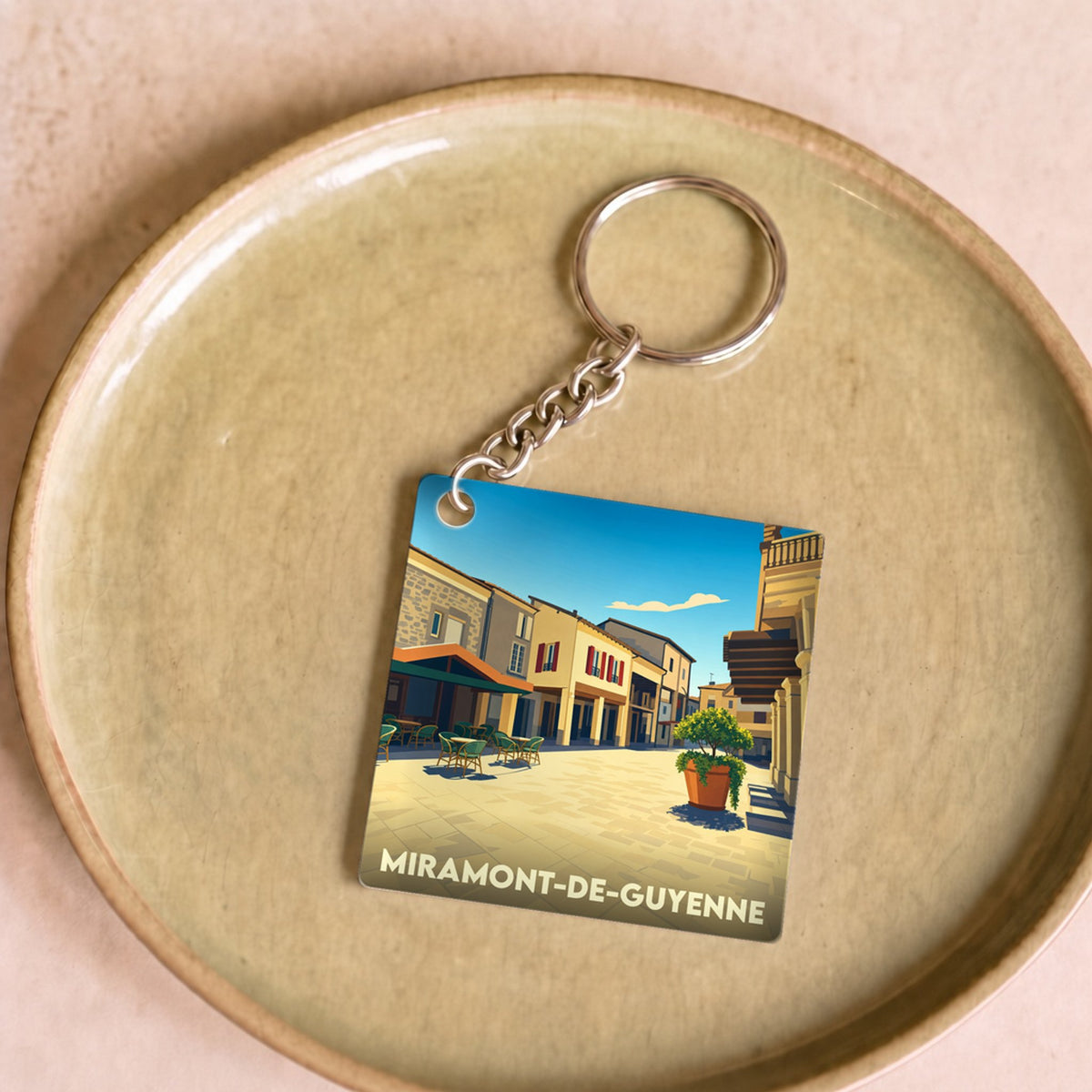 Porte-clés souvenir de la ville de Miramont-de-Guyenne avec une illustration stylisée.