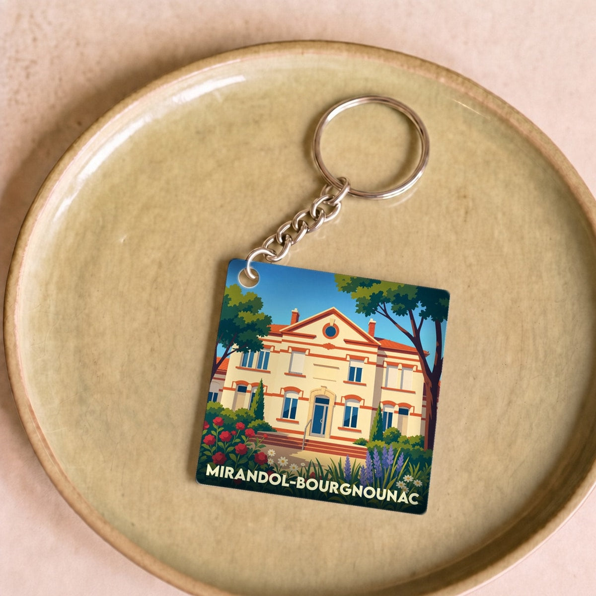 Porte-clés souvenir de la ville de Mirandol-Bourgnounac avec une illustration stylisée.