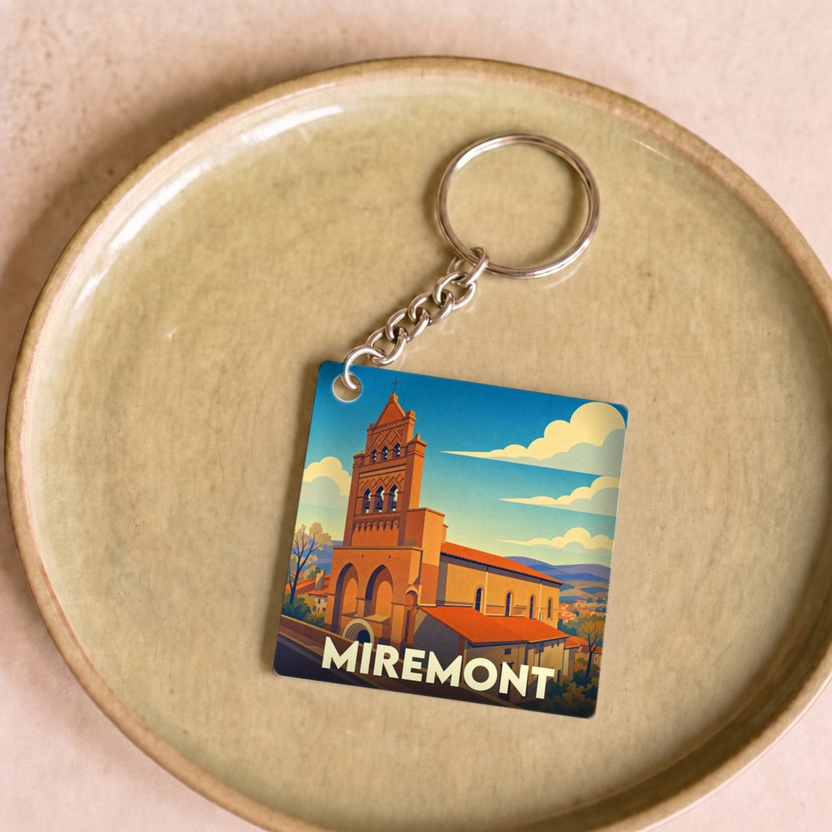 Porte-clés souvenir de la ville de Miremont avec une illustration stylisée de son église.