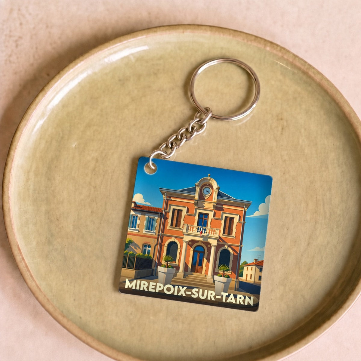 Porte-clés souvenir de la ville de Mirepoix-sur-Tarn avec une illustration stylisée de sa mairie.