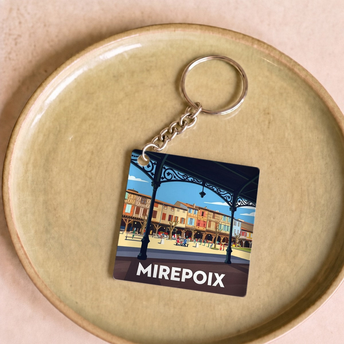 Porte-clés souvenir de la ville de Mirepoix avec une illustration stylisée.