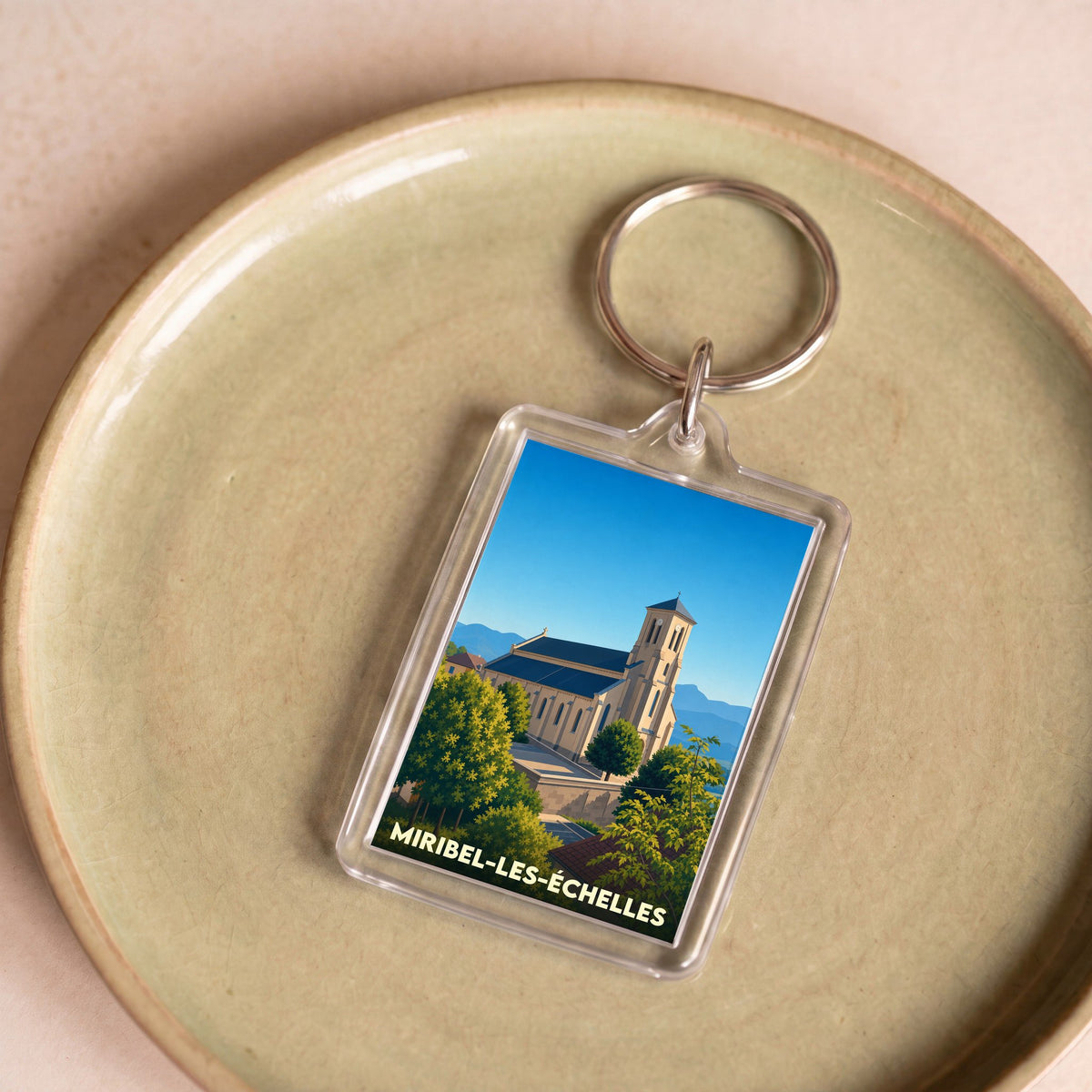 Porte-clés souvenir de la ville de Miribel-les-Échelles avec une illustration stylisée de son église.