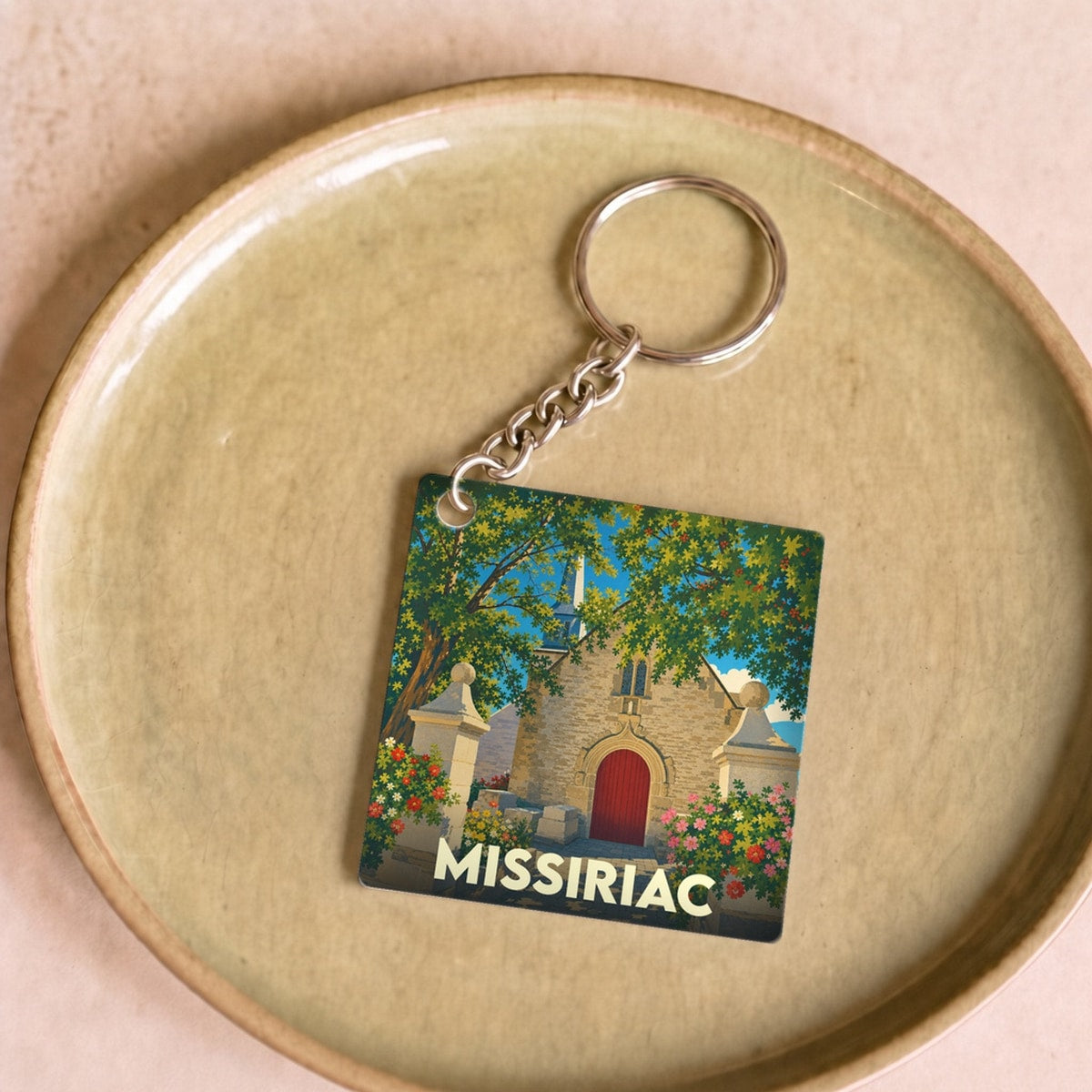 Porte-clés souvenir de la ville de Missiriac avec une illustration stylisée d'une église bretonne.