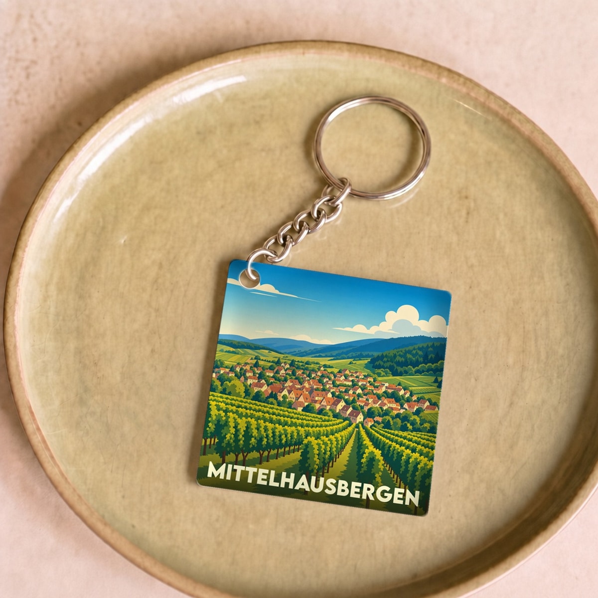 Porte-clés souvenir de la ville de Mittelhausbergen avec une illustration stylisée de vignobles et du village.