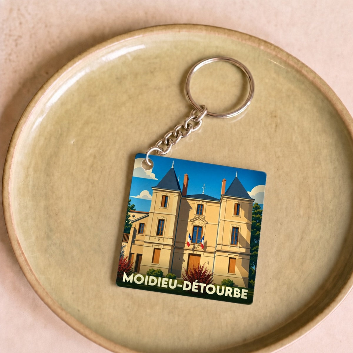 Porte-clés souvenir de la ville de Moidieu-Détourbe avec une illustration stylisée de son château.