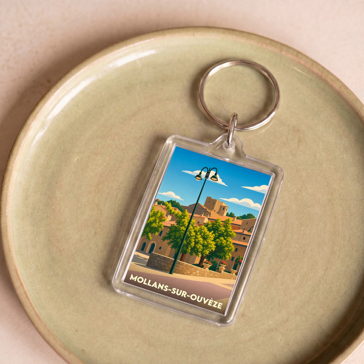 Porte-clés souvenir de la ville de Mollans-sur-Ouvèze avec une illustration stylisée.