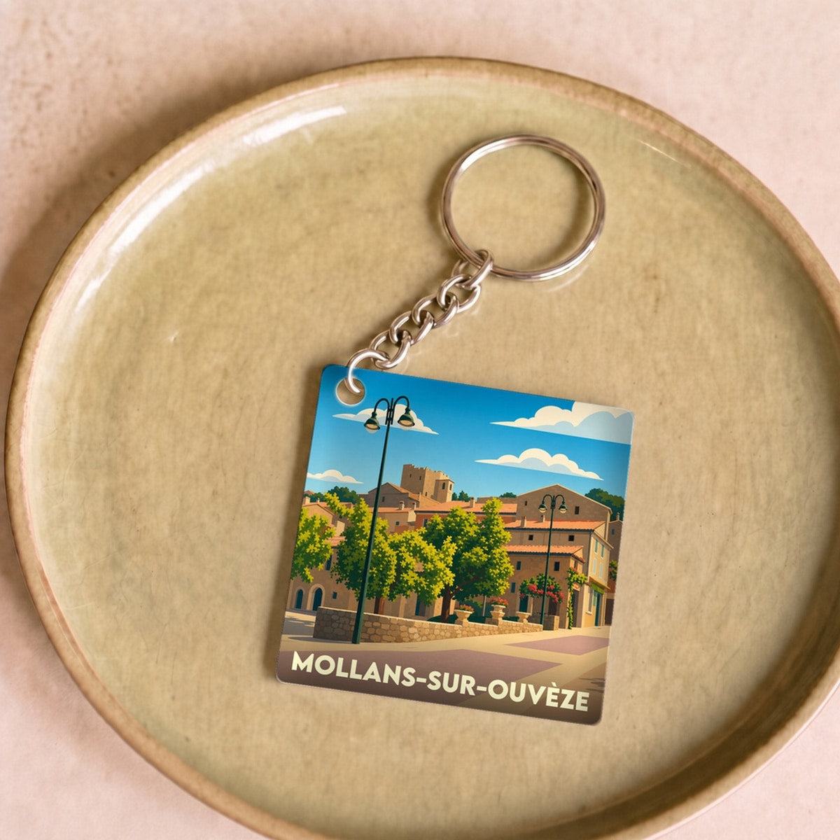 Porte-clés souvenir de la ville de Mollans-sur-Ouvèze avec une illustration stylisée.