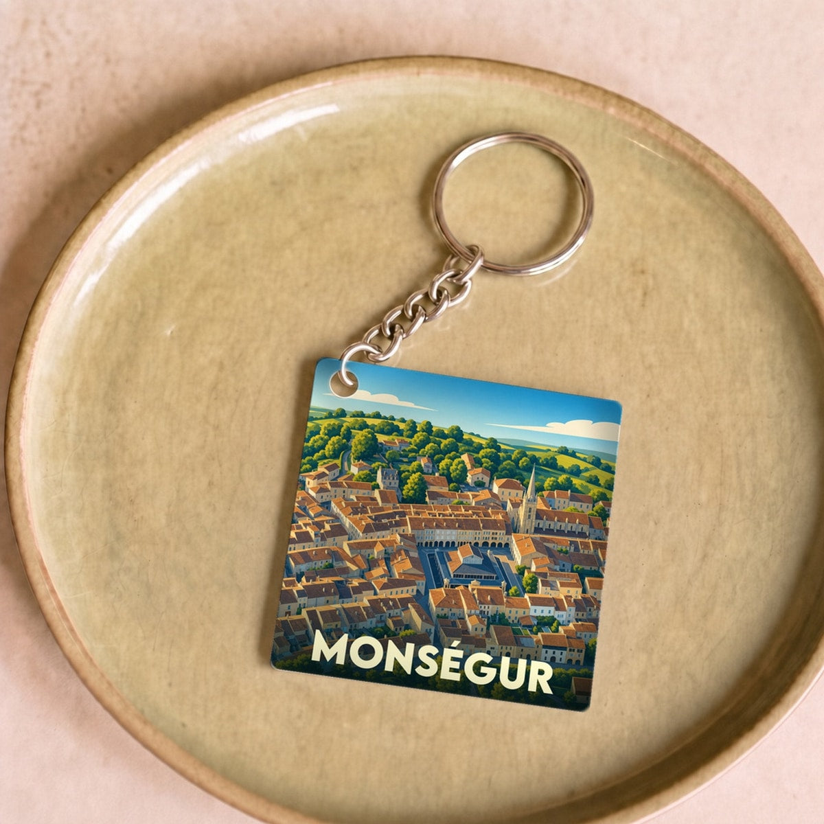 Porte-clés souvenir de la ville de Monségur avec une illustration stylisée.