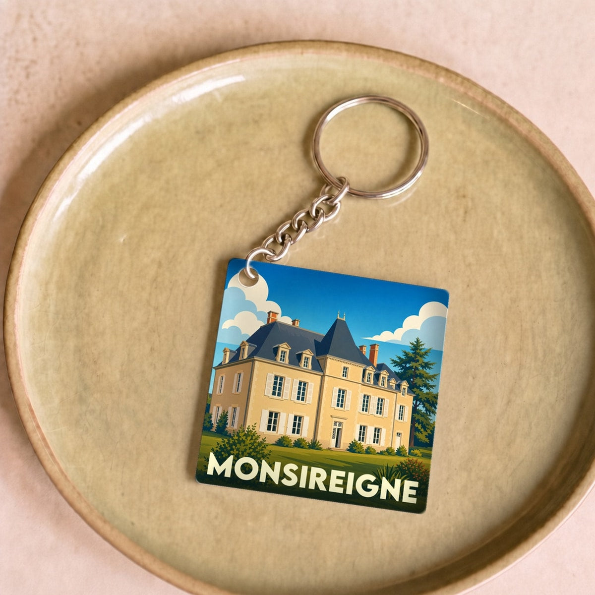 Porte-clés souvenir de la ville de Monsireigne avec une illustration stylisée.