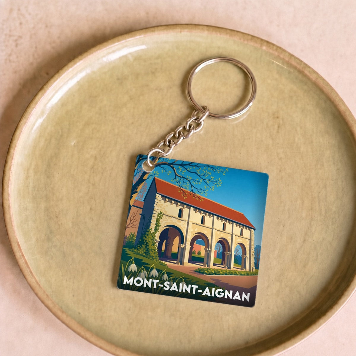Porte-clés souvenir de la ville de Mont-Saint-Aignan avec une illustration colorée et stylisée.
