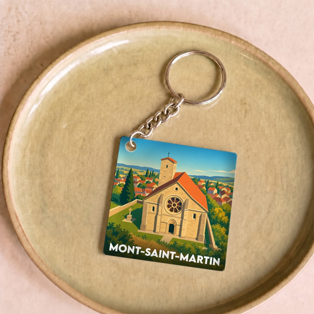 Porte-clés souvenir de la ville de Mont-Saint-Martin avec une illustration stylisée d'une église.