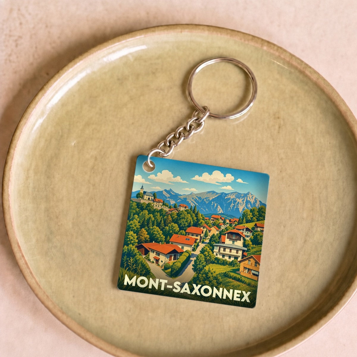 Porte-clés souvenir de la ville de Mont-Saxonnex avec une illustration stylisée de montagne.