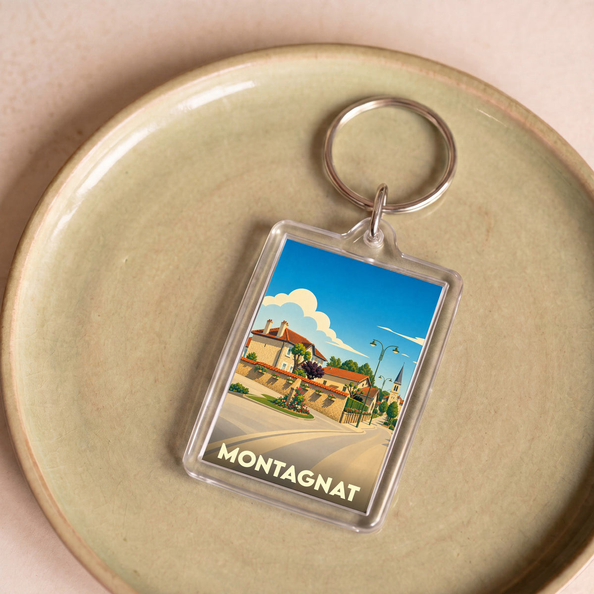 Porte-clés souvenir de la ville de Montagnat avec une illustration stylisée.